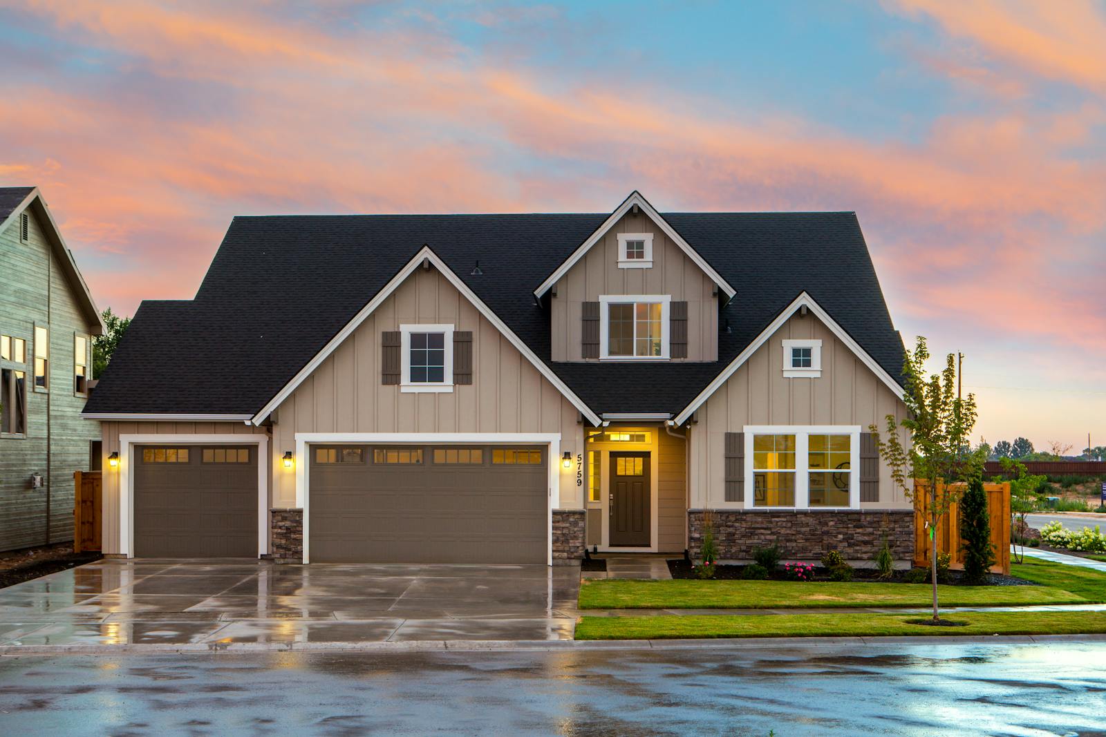 Suburban driveway at dusk, warm lights on, paved entry leading up to the house